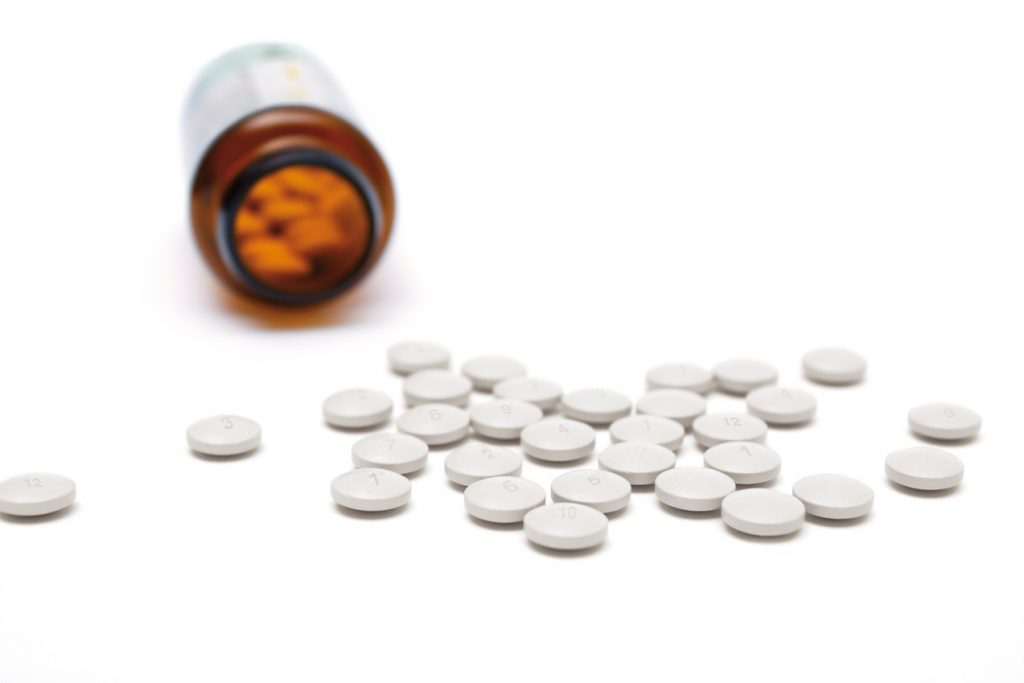 scattered pills with glass bottle with small depth of field